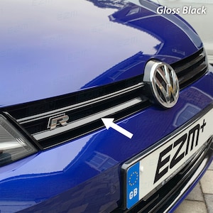 May include: Gloss black front grille for a blue car with a chrome "R" emblem and a black "EZM+" logo on the number plate.