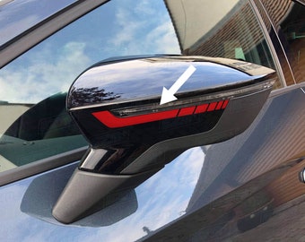May include: Black side view mirror with a red accent strip. The mirror is attached to a car.