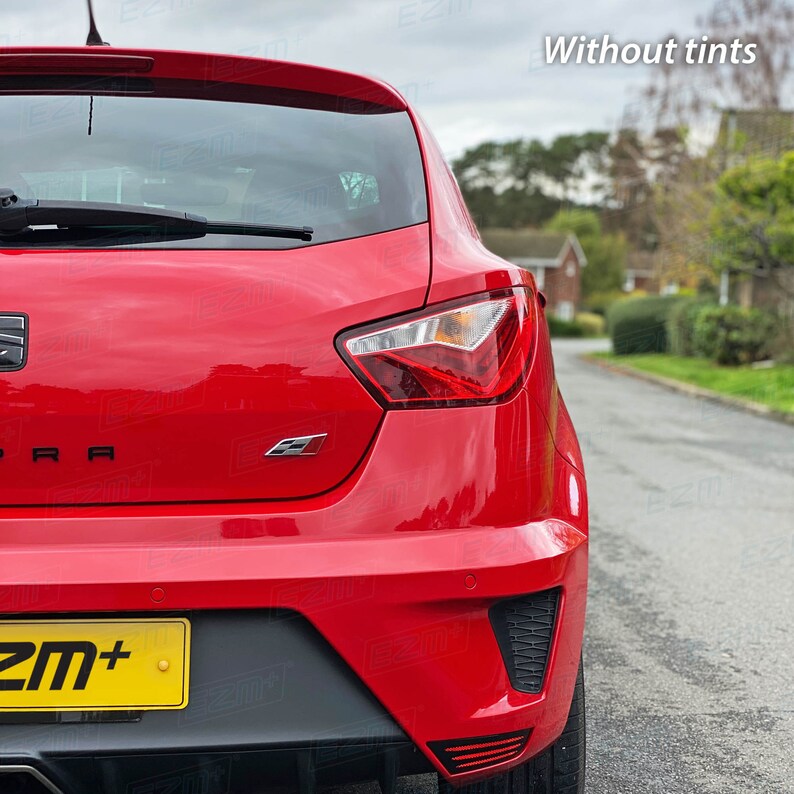 May include: Rear view of a red car with a black license plate that says "ZM+". The car has a black rear bumper with a black diffuser and a black spoiler. The car has a black rear window and a black rear windshield wiper. The car has a black rear emblem that says "CUPRA".