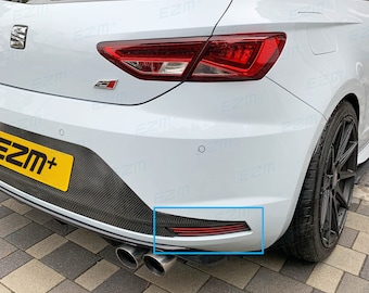 Puede incluir: Coche blanco de tipo hatchback con un difusor trasero de fibra de carbono negro y luces traseras rojas. El coche tiene una matrícula amarilla que dice "EZM+".