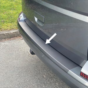 May include: A gray car with a black bumper. The bumper has a black trim piece that runs along the bottom edge. The trim piece is designed to protect the bumper from scratches and dents.