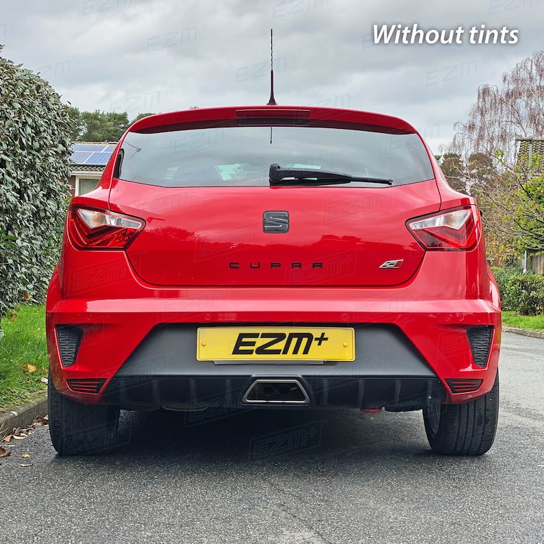 May include: A red SEAT Cupra car with a black rear bumper and a yellow license plate that reads "EZM+". The car has a black rear spoiler and a black rear diffuser.