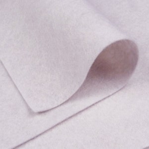 May include: A close-up of a light purple felt fabric. The fabric is soft and smooth, and it has a slightly textured surface.