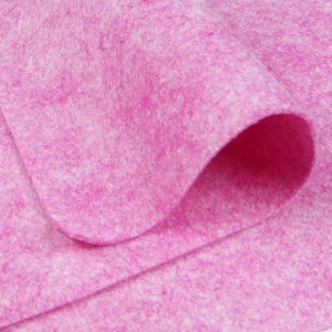 May include: A close-up of a pink felt fabric. The fabric is soft and fuzzy, with a slightly textured surface.