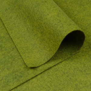 May include: A close-up of a piece of green felt fabric. The fabric is folded over itself, showing the texture of the material.
