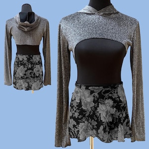 May include: A silver sparkly crop top with a black bodice and a black floral skirt. The top has a hood and long sleeves.