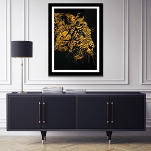 May include: A black and gold framed print of a tiger's face made of dollar bills. The tiger's eye is a bright blue.