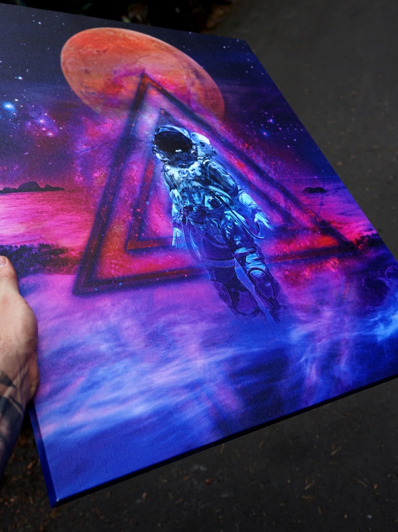 May include: A blue and purple space-themed painting with an astronaut floating in a triangle. The astronaut is wearing a white spacesuit and a helmet. The background is a nebula with a red planet.