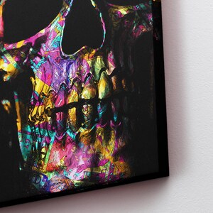 May include: A colorful, abstract skull with a black background. The skull is painted in a variety of bright colors, including pink, purple, yellow, and blue. The skull's teeth are visible and are painted in a bright yellow color.