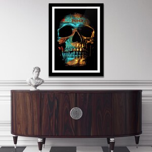 May include: A framed print of a skull with a gold and blue design. The skull is made up of dollar bills, with the number "100" visible on the forehead.