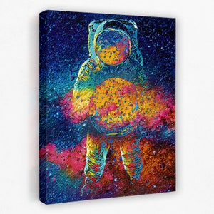 May include: A colorful abstract painting of an astronaut holding a planet in space. The astronaut is wearing a white spacesuit with a blue helmet. The planet is yellow and orange with a blue and purple nebula in the background.
