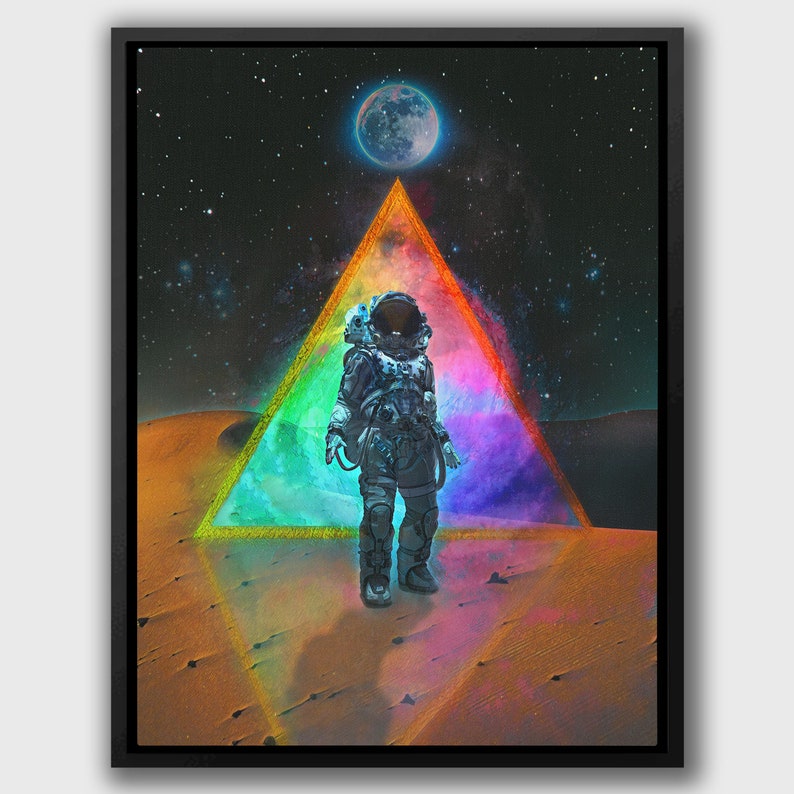 Op de afbeelding: Een astronaut in een wit ruimtepak staat op een rood, oranje en geel woestijnlandschap. Een grote, blauwe maan hangt aan de hemel boven een regenboogkleurige driehoek.
