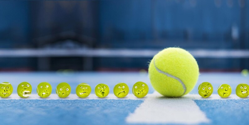 May include: A row of yellow tennis balls with different facial expressions, lined up on a blue tennis court. A single yellow tennis ball is in the foreground, slightly out of focus.