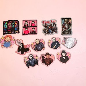 May include: A collection of horror movie themed stickers featuring various iconic characters. The designs include a Friends parody, Ghostface, Chucky, Jason Voorhees, Freddy Krueger, and Billy the Puppet, with some stickers featuring glittery accents and heart-shaped borders.