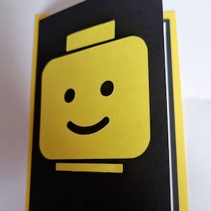 Tarjeta de felicitación en blanco hecha a mano con efecto 3D de cabeza de Lego