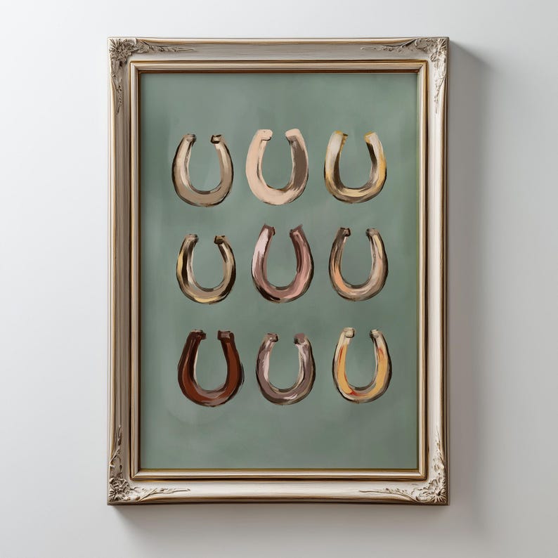 Puede incluir: Una l&aacute;mina de arte enmarcada que muestra nueve herraduras pintadas dispuestas en una cuadr&iacute;cula de tres por tres. Cada herradura presenta un tono &uacute;nico de marr&oacute;n, beige o ocre sobre un fondo verde salvia, dentro de un marco dorado.