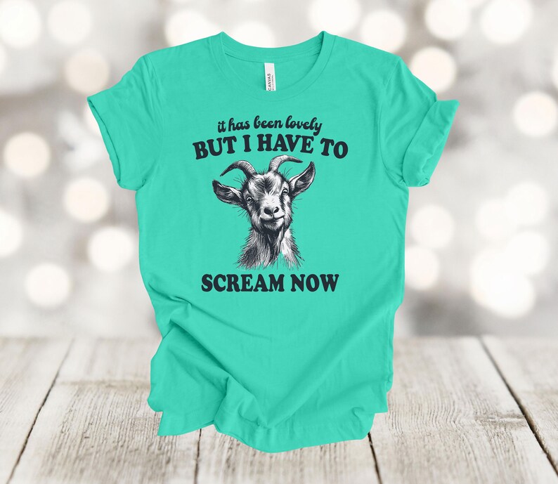 May include: A turquoise t-shirt with a black and white illustration of a goat and the text "it has been lovely BUT I HAVE TO SCREAM NOW".