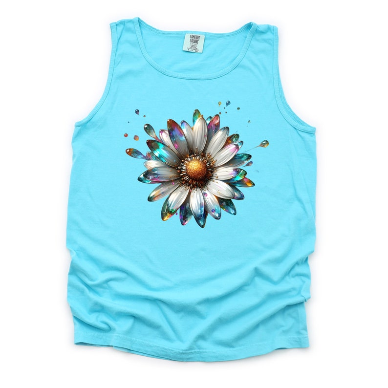 May include: A turquoise tank top with a colorful, metallic daisy graphic. The daisy has a white center and iridescent petals.