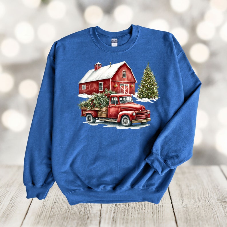 May include: A red pickup truck with a Christmas tree in the back, driving past a red barn with a snowy roof. The truck and barn are in front of a snowy background.