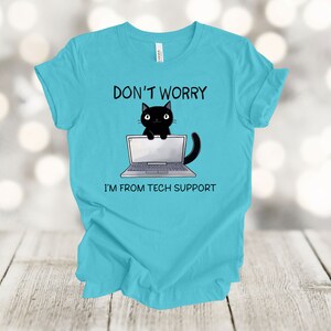 May include: A turquoise blue t-shirt with a black cat sitting on a laptop. The text on the shirt reads "Don't Worry I'm From Tech Support."