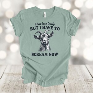 May include: A light green t-shirt with a black goat illustration and the text "it has been lovely BUT I HAVE TO SCREAM NOW".