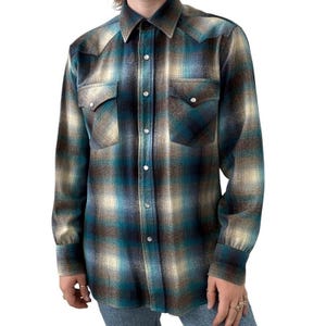 Peut inclure: Une chemise à manches longues à carreaux bleus, bruns et blancs avec un col boutonné et deux poches poitrine.