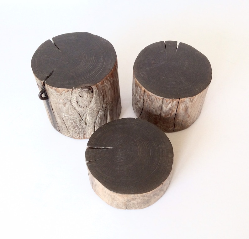 Peut inclure: Trois souches en bois de tailles diff&eacute;rentes, chacune avec un dessus brun fonc&eacute; et une base brun clair et patin&eacute;e. La plus grande souche a un anneau m&eacute;tallique fix&eacute; sur le c&ocirc;t&eacute;.