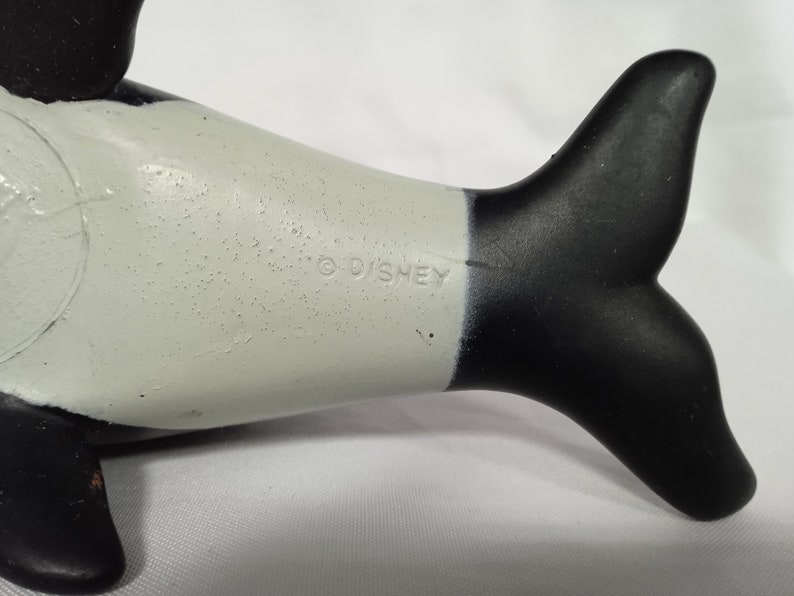 K&ouml;nnte beinhalten: Schwarz-wei&szlig;es Plastikspielzeug-Orca mit wei&szlig;em Bauch und schwarzem R&uuml;cken und Schwanz. Das Spielzeug hat ein Copyright-Symbol und den Schriftzug "DISNEY" auf der Seite.