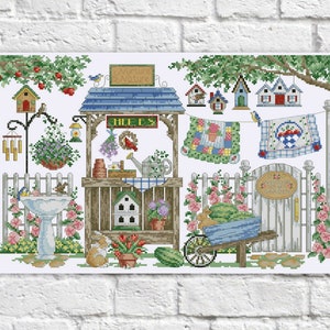 May include: A cross-stitch pattern featuring a whimsical garden scene with a birdhouse, a small wooden stand with the word "HERBS" on it, a wheelbarrow, a fence, and a sign that says "Welcome to my Garden".