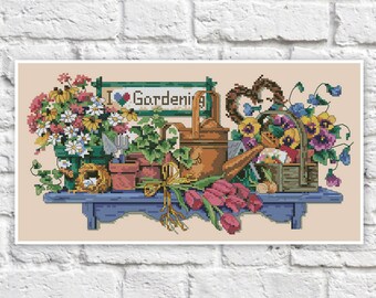 May include: A cross-stitch pattern featuring a blue shelf with gardening tools, flowers, and a sign that reads "I ♥ Gardening".