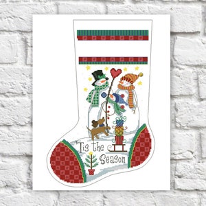 May include: A white Christmas stocking with a red and green checkered cuff. The stocking features a snowman family with a dog and the text "Tis the Season".