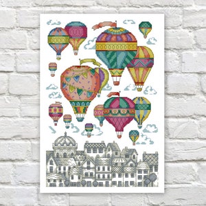 Puede incluir: Una ilustración colorida de globos aerostáticos con varios patrones y diseños flotando sobre un pequeño pueblo con casas y árboles. Los globos son en tonos de rojo, azul, verde, amarillo y naranja.