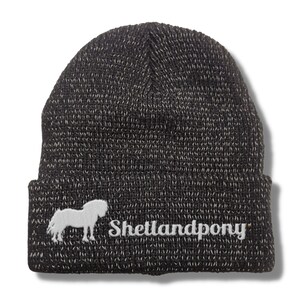 Könnte beinhalten: Schwarze Strickmütze mit einer weißen Silhouette eines Shetlandponys und dem Schriftzug "Shetlandpony" auf der Vorderseite.