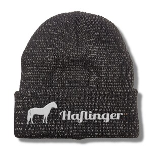 Könnte beinhalten: Schwarze Strickmütze mit einer weißen Pferdesilhouette und dem Wort "Haflinger" vorne bestickt.