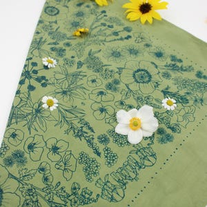 Peut inclure: Un bandana vert avec un imprim&eacute; floral bleu fonc&eacute;. Le bandana est d&eacute;cor&eacute; de fleurs blanches et jaunes.