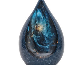 May include: A teardrop-shaped urn with a dark blue speckled exterior. The interior features a vibrant depiction of a nebula with swirling blues, golds, and whites. The urn is designed to hold cremated remains.