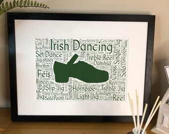 Może przedstawiać: Wydruk w ramie przedstawiający zielony irlandzki taniec z chmurą słów z terminami irlandzkiego tańca, w tym "Jig", "Reel", "Treble", "Set Dance", "Féis", "Rince", "Hornpipe", "Damhsa", "Ghillies", "Solo", "Cross", "Light", "Switch", "Turnout", "Overs", "Sevens", "Céilí", "Love", "Beats", "Riverdance", "Single", "Music" i "Dancing".