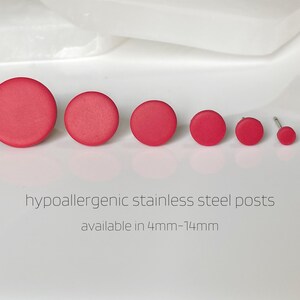 May include: A set of seven red round stud earrings with hypoallergenic stainless steel posts. The earrings are available in sizes from 4mm to 14mm.  hypoallergenic stainless steel posts available in 4mm-14mm