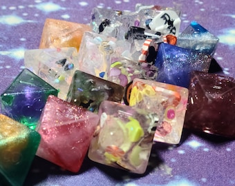 May include: A collection of 12 colorful, glittery, resin dice with various patterns and designs. The dice are shaped like pyramids and have a variety of colors, including purple, pink, green, blue, and white.