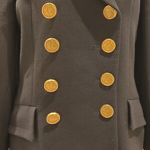 May include: A black double-breasted blazer with gold buttons featuring a decorative design.