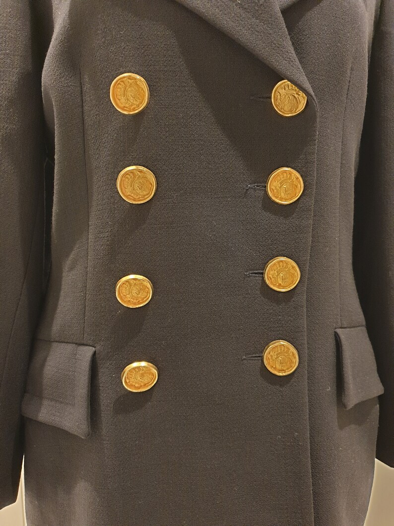 May include: A black double-breasted blazer with gold buttons featuring a decorative design.