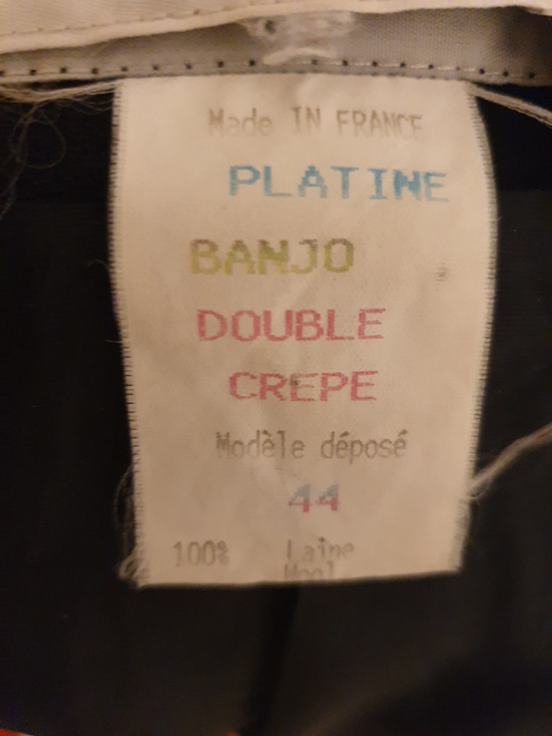 May include: White tag with black text that reads "Made in France", "Platine", "Banjo", "Double Crepe", "Mod&egrave;le d&eacute;pos&eacute;", "44", and "100% laine wool".