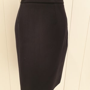 May include: A black pencil skirt with a straight silhouette and a high waist.