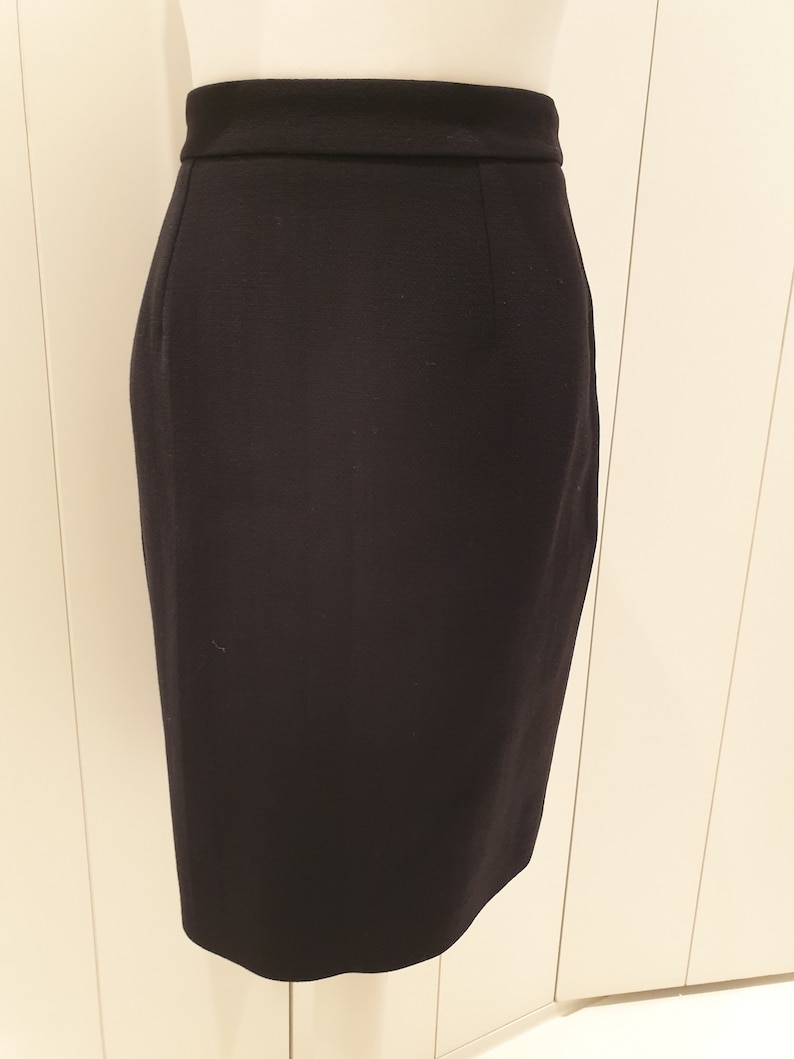 May include: A black pencil skirt with a straight silhouette and a high waist.