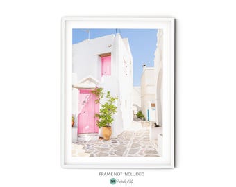 Puede incluir: Un edificio blanco con una puerta rosa brillante y una planta en maceta delante. El edificio está en un callejón estrecho con paredes blancas a cada lado. El cielo es azul y hay un toque de sol.