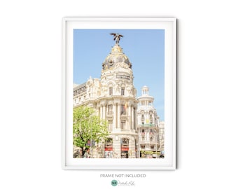 May include: A white building with a large dome and a statue on top. The building is decorated with ornate details and has a blue sky in the background.