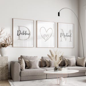 May include: Three framed wall art prints with names and a heart design. The first print says "Debbie" with a large letter "D". The second print has a heart design. The third print says "Michael" with a large letter "M".