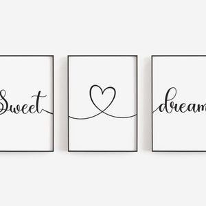 May include: Three black framed prints with white backgrounds. The left print says "Sweet" in cursive. The middle print has a simple line drawing of a heart. The right print says "dreams" in cursive.