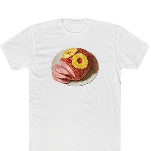 May include: A white t-shirt with a graphic of a ham with pineapple rings and a cherry on top.