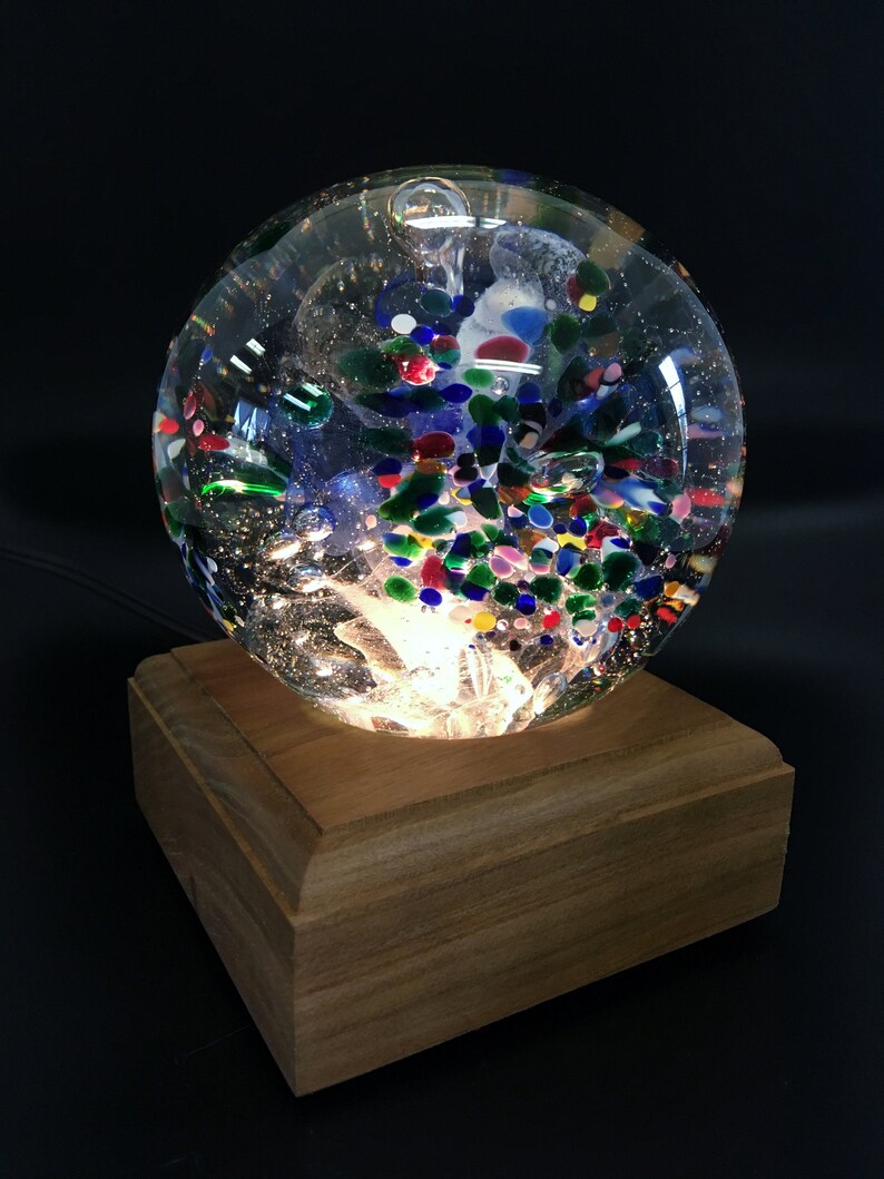 Blue and Red Mix BlueWhite center with Green Blown Glass Large Tri-Flower Paperweight on a Dark Wooden Light Box